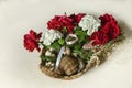 Red roses, white hydrangeas, decorated with branches of eucalyptus with seashells in a straw basket Royalty Free Stock Photo