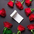 Red roses and white open gift box on black colored paper background, square photo Royalty Free Stock Photo