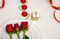 Red Roses on a white plate, candles and giftbox. Romantic composition for Valentine`s Day, Anniversary, Events. Place Royalty Free Stock Photo