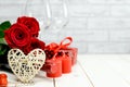 Red roses, wine set, heart, candles and gift box. Valentine`s Day greeting card Royalty Free Stock Photo
