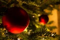 Red round Christmas ornament glistening on the tree with lights Royalty Free Stock Photo