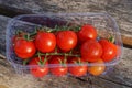 Red round fresh tomatoes on a green branch in a white plastic box Royalty Free Stock Photo