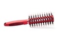 Red round hairbrush with bristle isolated on white