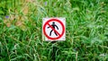 Red round prohibition sign with a black silhouette of a man crossed out. Prohibition to walk on the grass. Panoramic format