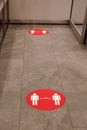 Red round sign printed on ground at supermarket cash desk register informing people to keep 2 meter 6 feet distance from Royalty Free Stock Photo