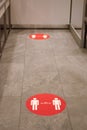 Red round sign printed on ground at supermarket cash desk register informing people to keep 2 meter 6 feet distance from Royalty Free Stock Photo