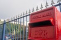 Red royal mail post box UK, with fence in background