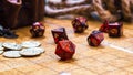 Red RPG dice and golden gaming coins on a battle map