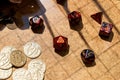 Red RPG dice and golden gaming coins on a battle map Royalty Free Stock Photo