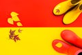 Two pair of colourful rubber boots standing on yellow and red background. Royalty Free Stock Photo