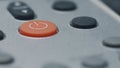 Red rubber button ON or OFF against the background of a white plastic device or remote control. Gray buttons on the background. Royalty Free Stock Photo