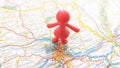 A red rubber toy women standing in Vienna on a map of Austria