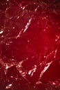 red rumpled foil or polyethylene on a red background. Hard light, facets of folds. Abstract background for design