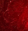 red rumpled foil or polyethylene on a red background. Hard light, facets of folds. Abstract background for design