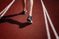 Red running track with female runner, close up on legs Royalty Free Stock Photo