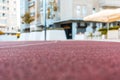 Red running track sports texture surface with field blur Royalty Free Stock Photo