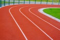 Red running track with white lines in outdoor sport stadium, side is a field and park. Backgrounds and rubber. Royalty Free Stock Photo