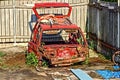 Red rusted and scraped car wreck.