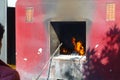 A red rustic oven in outdoors, with fire inside at Tsz wan temple, in Hong Kong