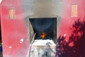 A red rustic oven in outdoors, with fire inside at Tsz wan temple, in Hong Kong