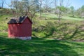 Red rustic wooden shed in a green grass field Royalty Free Stock Photo