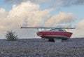 Red sailing boat beached on stones