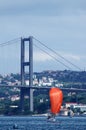 Red sailing boat and bridge