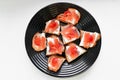 Red salmon on white bread. bagel and lox. view from above. black plate on a white background Royalty Free Stock Photo