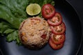 Red salted egg fried rice with vegetables in black plate Royalty Free Stock Photo