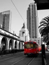 Monochrome photo with red San Diego trolley, outside the rail station.