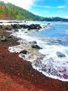 Red sand beach with lava rocks on the coast in Maui Hawaii