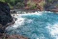 Red Sand Beach, Maui in in Hawaiian. Ocean waves and rock. Royalty Free Stock Photo