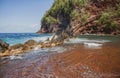 Red Sand Beach, Maui in in Hawaiian. Ocean waves and rock. Royalty Free Stock Photo
