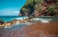 Red Sand Beach, Maui in in Hawaiian. Ocean waves and rock. Royalty Free Stock Photo