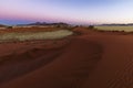 Red sand dune blue and pink sky after sunset