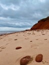 Red sandstone cliffs and the sand at Cavendish Beach under cloudy sky, Prince Edward Island, Canada Royalty Free Stock Photo