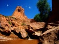 Red sandstone tower with stream and waterfall in Coyote Gulch canyon in Escalante, Utah