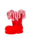 Red Santa Claus boots with colored sweet lollipops, candies, shoes with Merry Christmas yellow sparkly write. Saint Nicholas boots Royalty Free Stock Photo