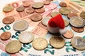 Red santa claus hat on a background of euro coins and banknotes. Background of european money. The concept of New Year and Royalty Free Stock Photo