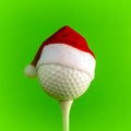 A red Santa Claus hat is worn on a golf ball mounted on a tee. Bright green background. Square frame for avatars or illustrating Royalty Free Stock Photo