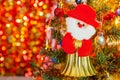 Red Santa doll is an ornament on a Christmas tree against light background for Christmas Day and New Year holidays background. Royalty Free Stock Photo