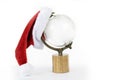 Red Santa hat on an isolated white background sitting on globe world copy space Royalty Free Stock Photo