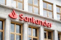 Red Santander bank logo on a facade of a modern bank branch building embedded in an urban city setting. News shot, Spanish