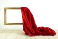 red satin cloth unveiling a golden frame. Levitating frame