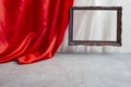 red satin curtain unveiling a wooden frame and cement textured stagee