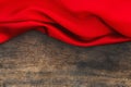 Red satin fabric on brown wood background