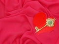 Red satin material with key to heart shape love concept Royalty Free Stock Photo