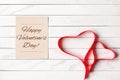 Red Satin Ribbon in Shape of Two Hearts on Wooden Background Royalty Free Stock Photo