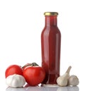 Red sauce in a bottle and fresh ingredients, tomatoes and garlic on a white isolated background. Tomato sauce. Ketchup Royalty Free Stock Photo