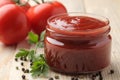 Red sauce in a jar close-up with fresh tomatoes on a natural wooden table Royalty Free Stock Photo